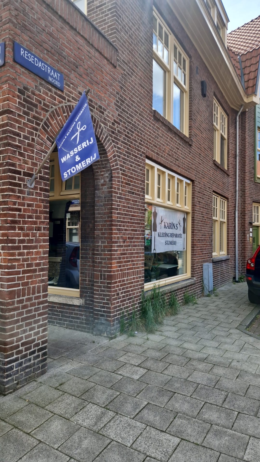 Karin's Kledingreparatie aan de Duizendschoonstraat in Amsterdam-Noord — gevel met blauwe vlag